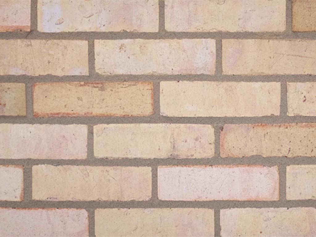 CLose up of a wall of Mixed Yellow bricks