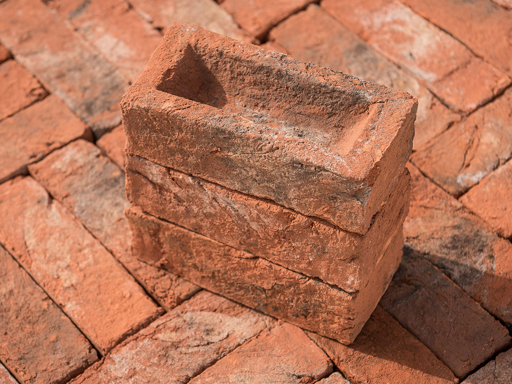 A stack of Weathered Orange Handmade bricks