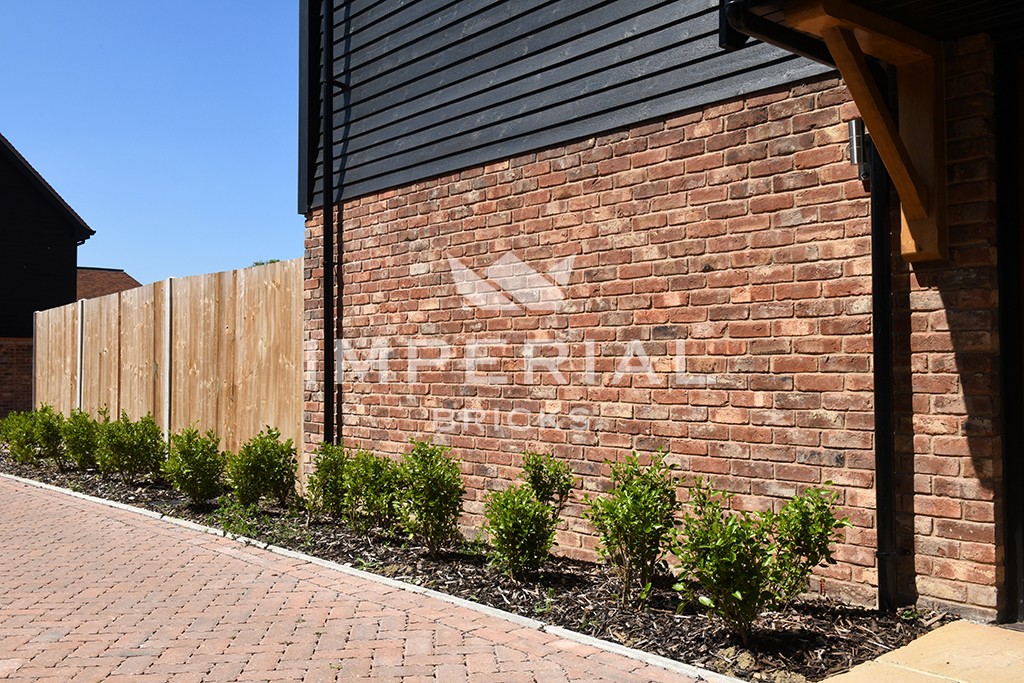 A garden with Tumbled Reclamation Red bricks in the background