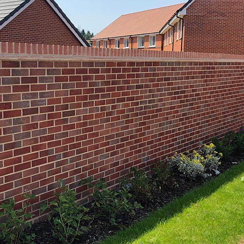 A garden wall built using Graven Red Multi bricks