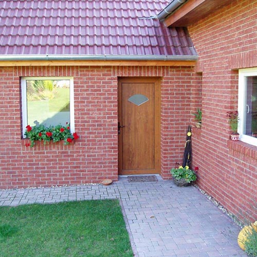 A garden with Anglian Red Handmade bricks in the background
