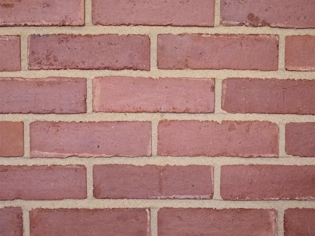 Close up of a wall of Old Victorian Pressed Medium Dark bricks