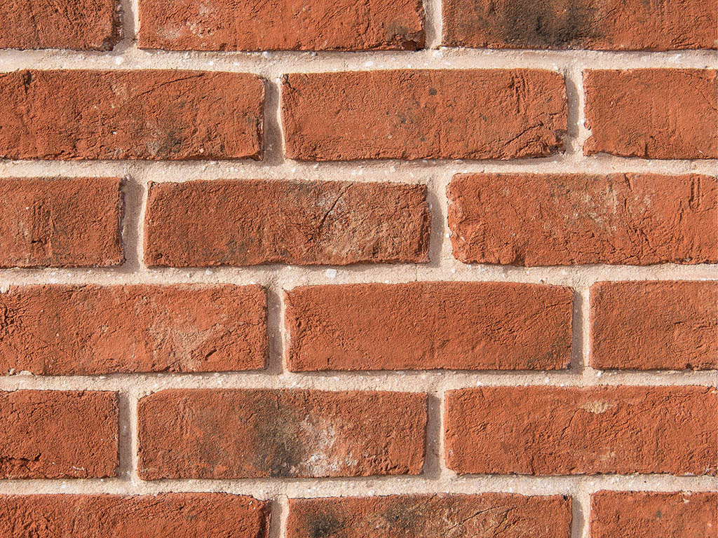Close up of a wall of Weathered Orange Handmade bricks