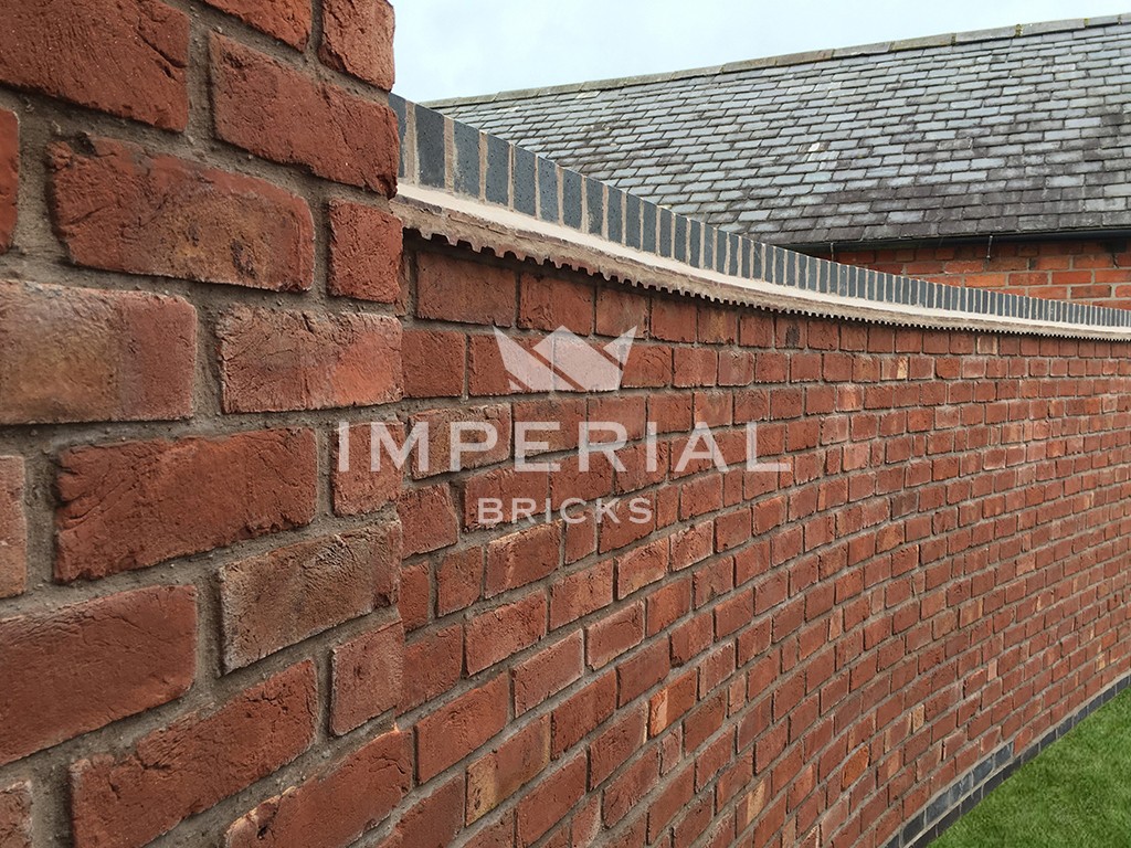 A boundary wall built using Red Handmade bricks